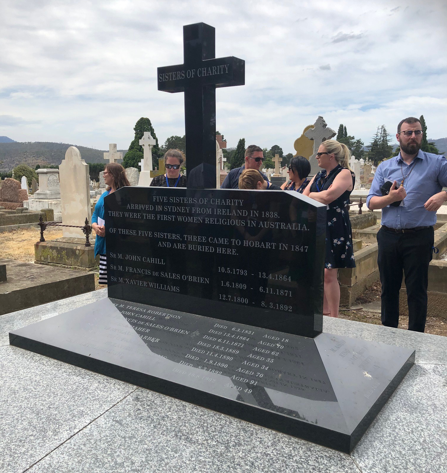 Pilgrims paying their-respects at the-final resting place of the Three Sisters at Cornelian Bay Cemetery